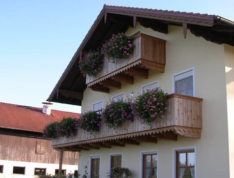 Holzbalkone mit blühenden Blumenkästen an einem oberbayerischen Haus
